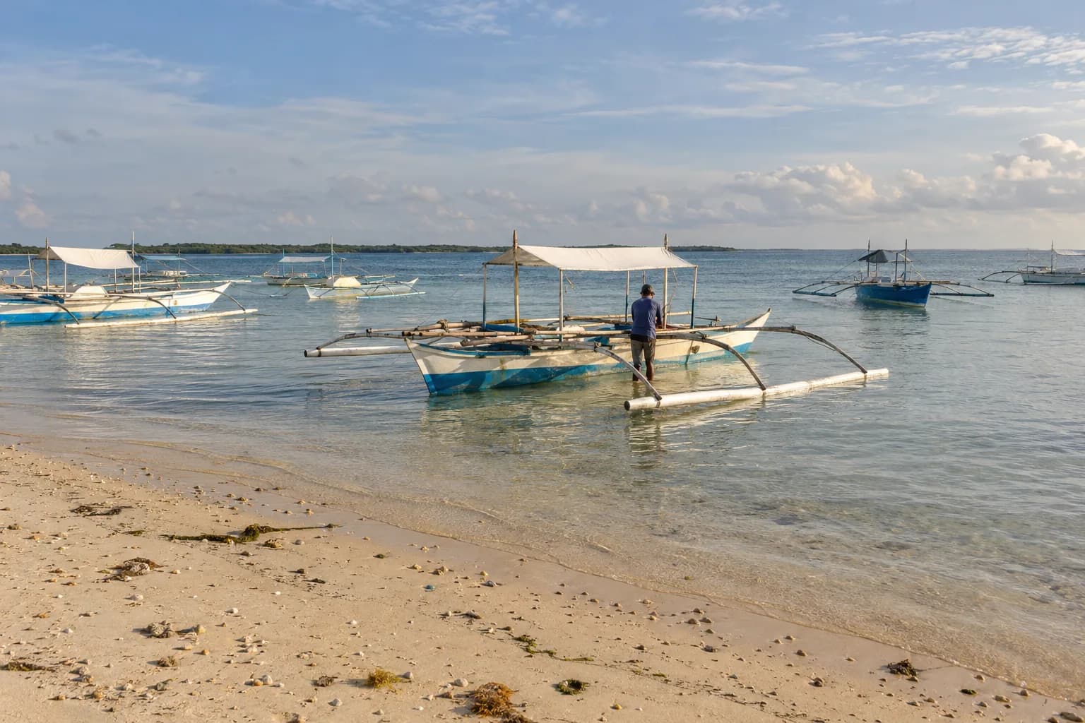 Outrigger boats in the shallows of the General Luna seafront, Siargao, late afternoon